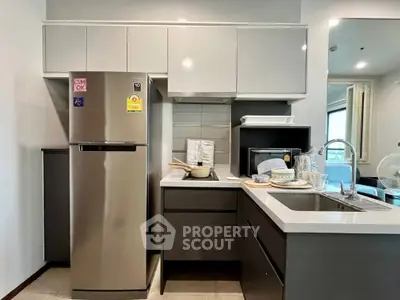 Modern kitchen with sleek cabinetry and stainless steel appliances in a stylish apartment.