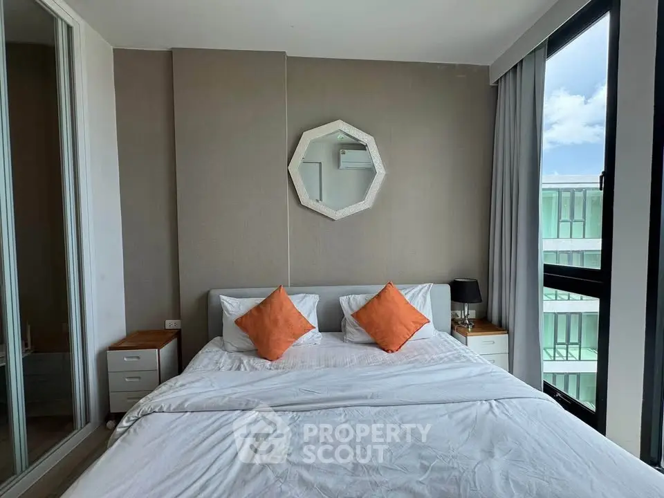 Modern bedroom with large windows and stylish decor in a high-rise apartment.