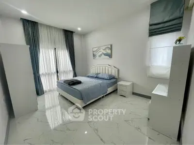 Spacious bedroom with modern decor and large windows for natural light.