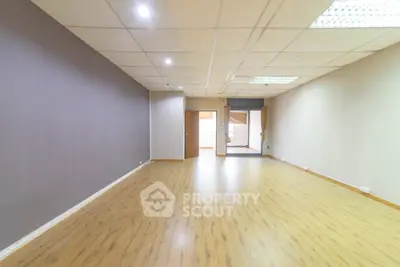Spacious empty room with wooden flooring and neutral walls ideal for customization
