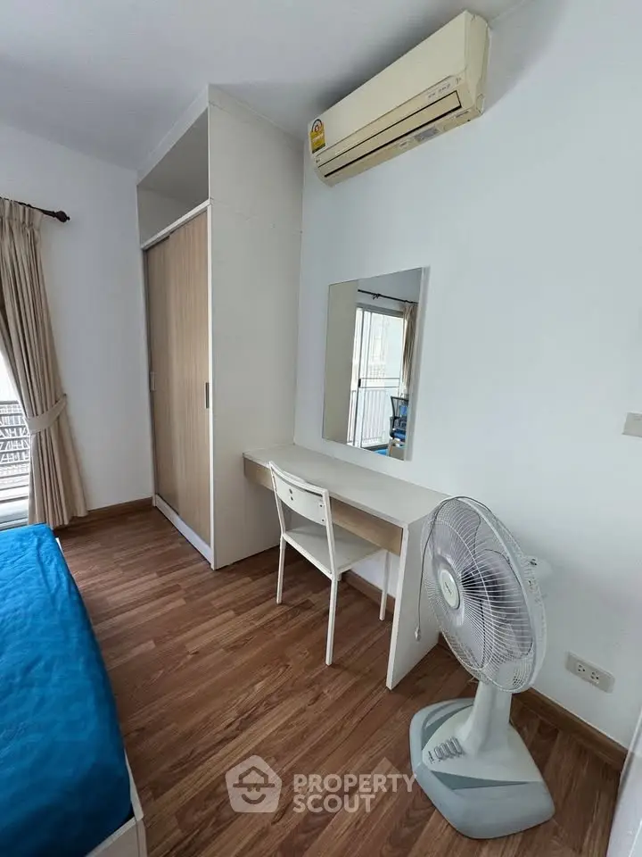 Cozy bedroom with wooden flooring, built-in wardrobe, and air conditioning, perfect for comfortable living.