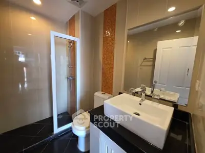 Modern bathroom with sleek fixtures and glass shower enclosure