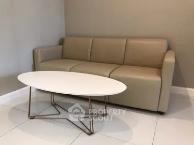 Modern living room with beige sofa and sleek white coffee table.