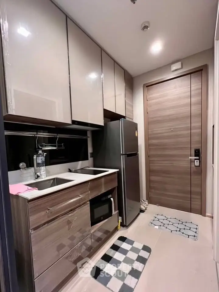 Modern kitchen with sleek cabinetry and stainless steel appliances in a compact layout.