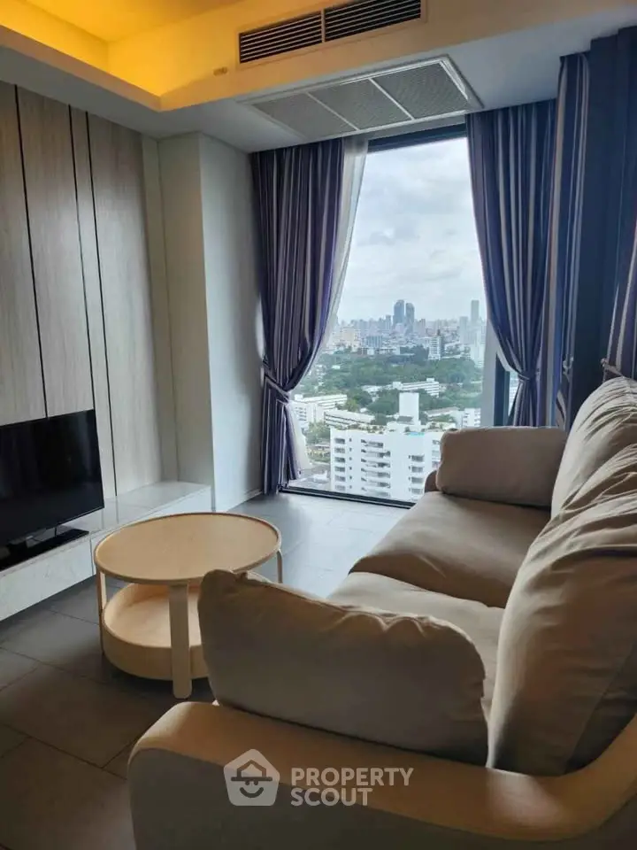 Modern living room with panoramic city view, cozy sofa, and stylish decor in high-rise apartment.