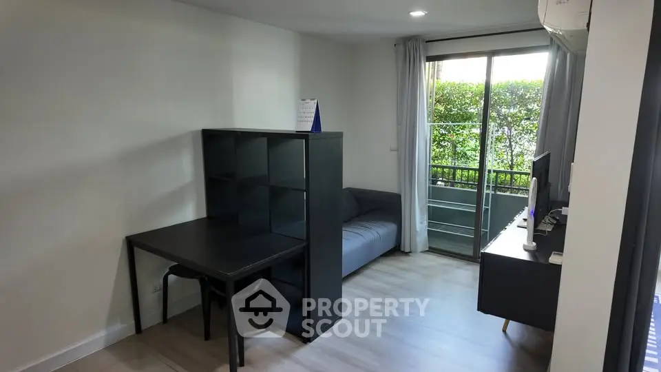 Modern living room with sleek furniture and balcony access, perfect for urban living.