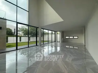 Spacious modern living room with floor-to-ceiling windows and glossy marble flooring.