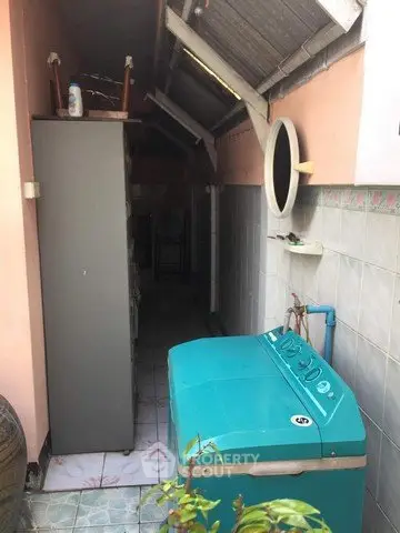 Compact laundry area with washing machine in narrow outdoor space