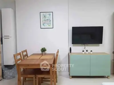 Modern living room with wooden dining set and wall-mounted TV for cozy home ambiance.