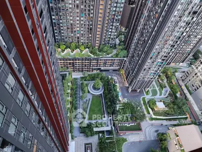 Stunning aerial view of modern high-rise residential complex with lush green landscaping and urban architecture.