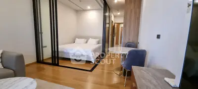 Modern studio apartment with glass partitioned bedroom and stylish furnishings.