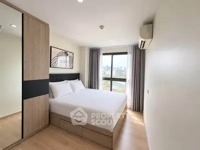 Modern bedroom with city view, featuring sleek design and ample natural light.