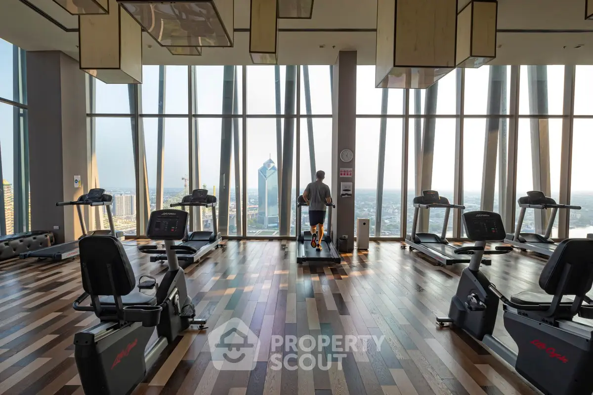 Luxurious high-rise gym with panoramic city views and modern fitness equipment.
