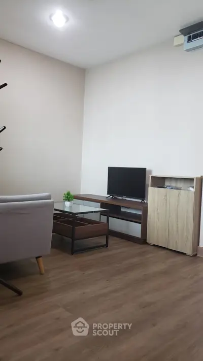 Modern living room with sleek furniture and wooden flooring, perfect for cozy gatherings.
