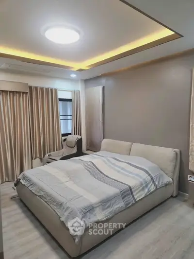 Spacious bedroom with modern lighting and cozy decor, perfect for relaxation.