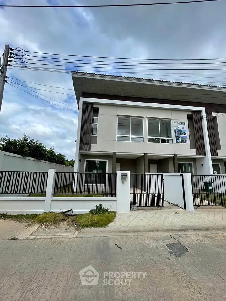 Modern two-story townhouse with sleek design and spacious front yard in a serene neighborhood.