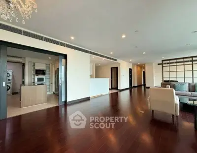 Spacious open-plan living room with hardwood floors and modern kitchen