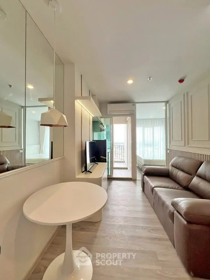 Modern living room with sleek furniture and balcony view in a stylish apartment.