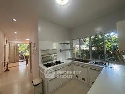 Spacious kitchen with dual sinks and garden view, ideal for culinary enthusiasts.