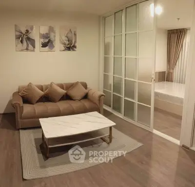 Stylish living room with elegant sofa and sliding glass doors leading to a cozy bedroom.