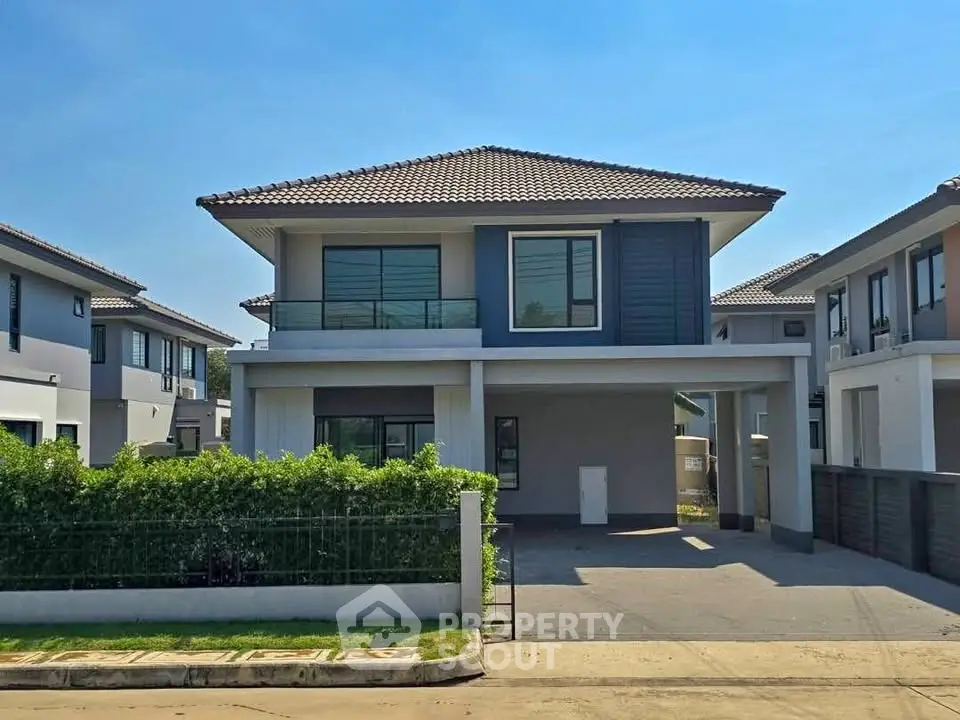 Modern two-story house with spacious driveway and lush greenery in a serene neighborhood.
