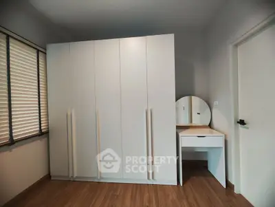 Modern bedroom with sleek white wardrobe and vanity mirror