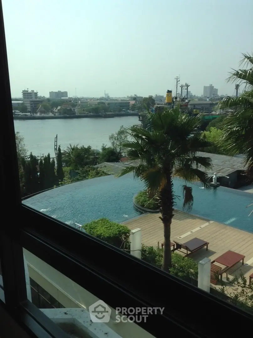 Luxurious riverside view from a high-rise apartment with infinity pool and lush greenery.