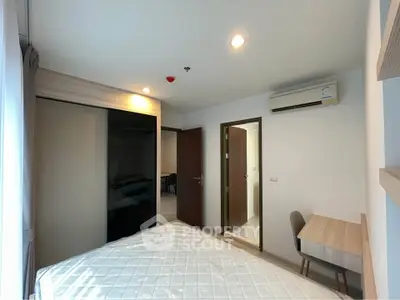 Modern bedroom with sleek design, featuring a comfortable bed, built-in wardrobe, and a compact study area.