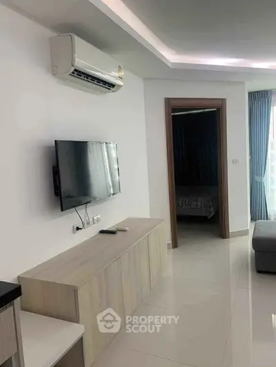 Modern living room with wall-mounted TV and air conditioning in a stylish apartment.