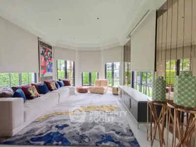 Luxurious living room with modern decor and large windows offering garden views.