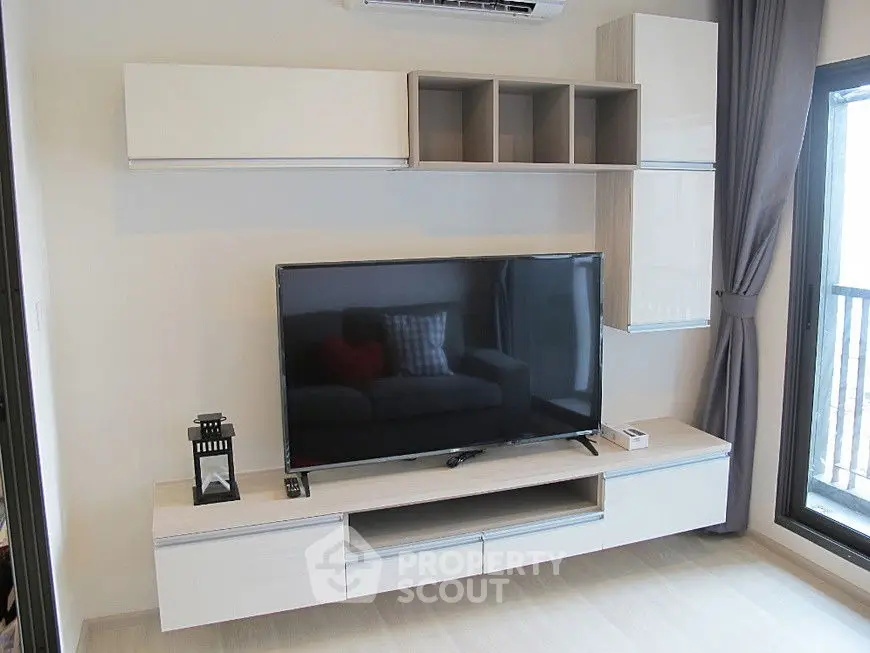 Modern living room with sleek TV unit and balcony view