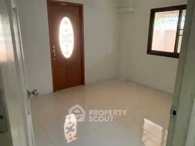 Spacious unfurnished room with elegant wooden door and tiled flooring