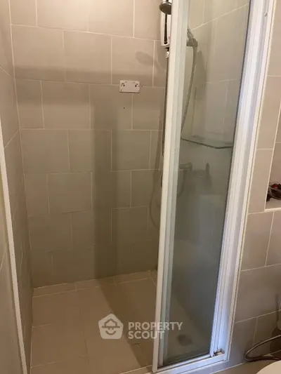 Modern bathroom shower with glass door and tiled walls