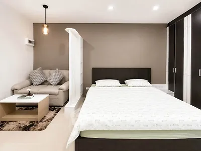Modern studio apartment with cozy bed and stylish sofa in open layout.