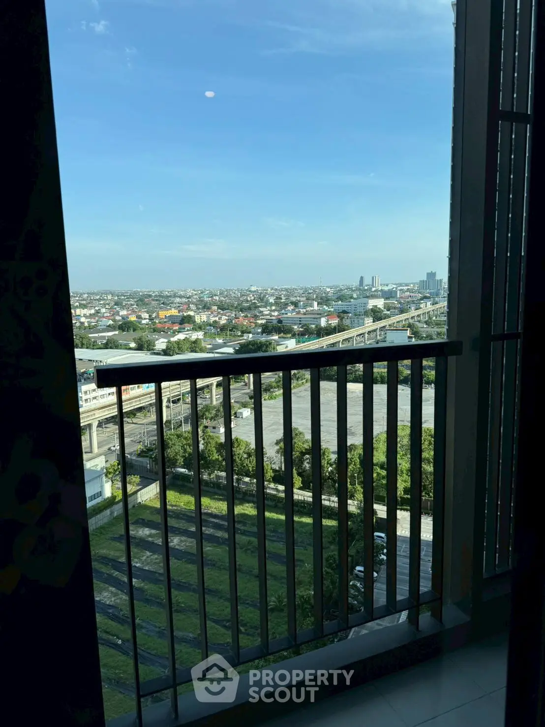 Stunning cityscape view from a high-rise balcony with clear skies.