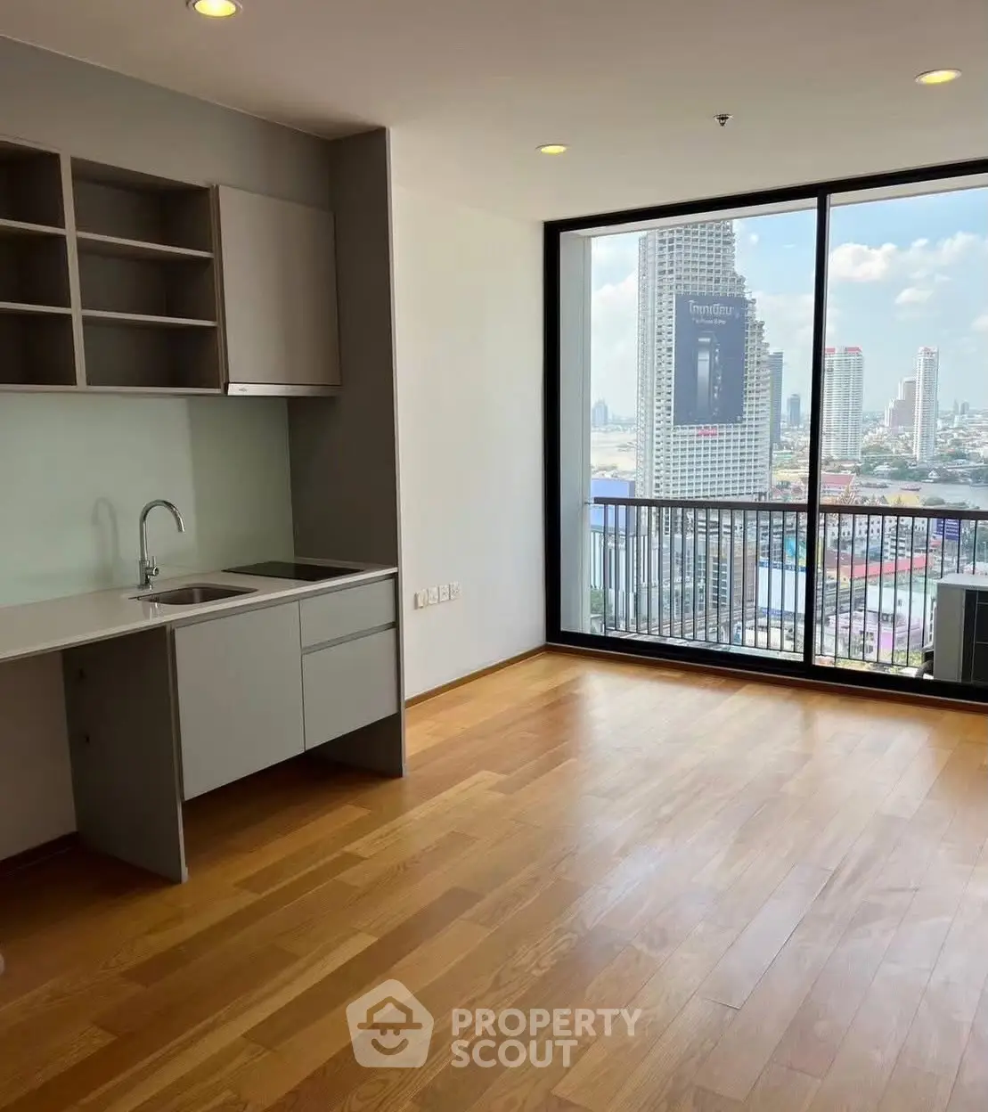 Spacious modern living room with open kitchen and stunning city view balcony.