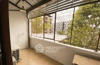 Spacious balcony with metal railing and scenic view of trees and buildings, perfect for relaxation.