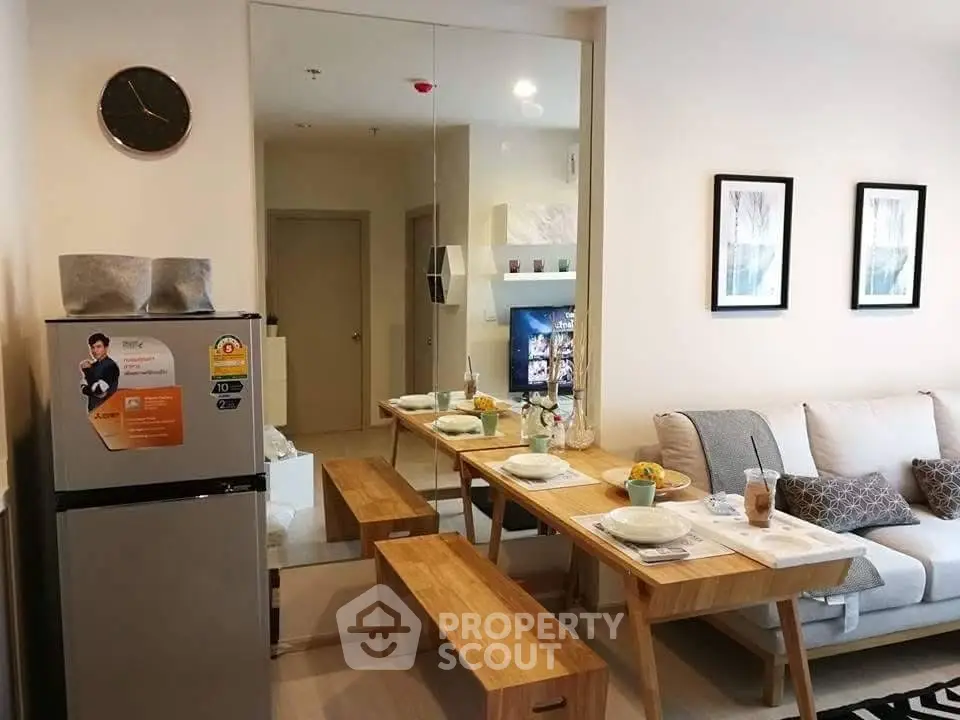 Modern living room with dining area and stylish decor, featuring a compact fridge and wooden furniture.