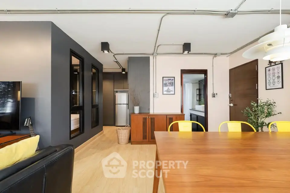 Modern dining area with wooden table and yellow chairs in stylish apartment
