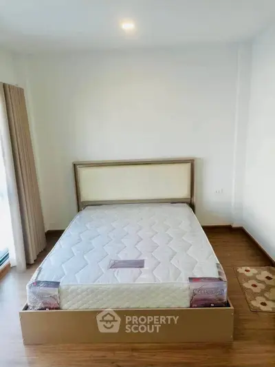 Spacious bedroom with new mattress and wooden flooring in modern apartment