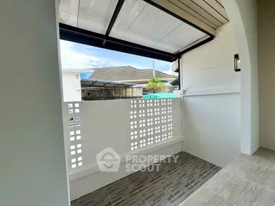 Charming small balcony with modern tiles and partial roof cover, perfect for relaxation.