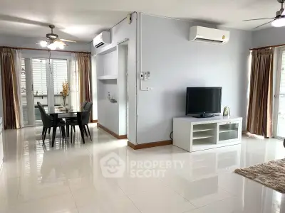 Spacious modern living room with dining area and sleek furnishings in a bright, airy apartment.