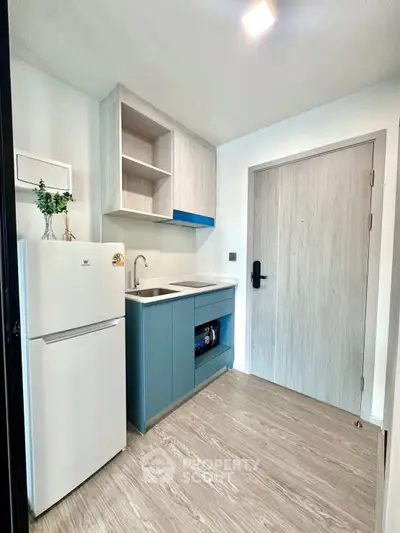 Modern compact kitchen with sleek cabinetry and integrated appliances