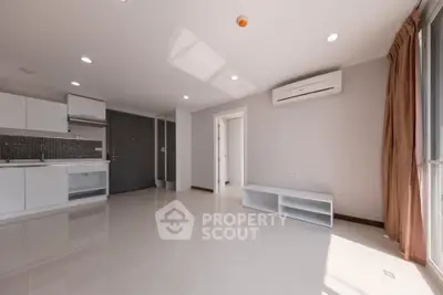 Spacious modern living room with open kitchen and natural light