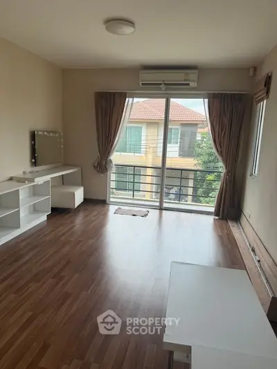 Spacious living room with wooden flooring and large window balcony view