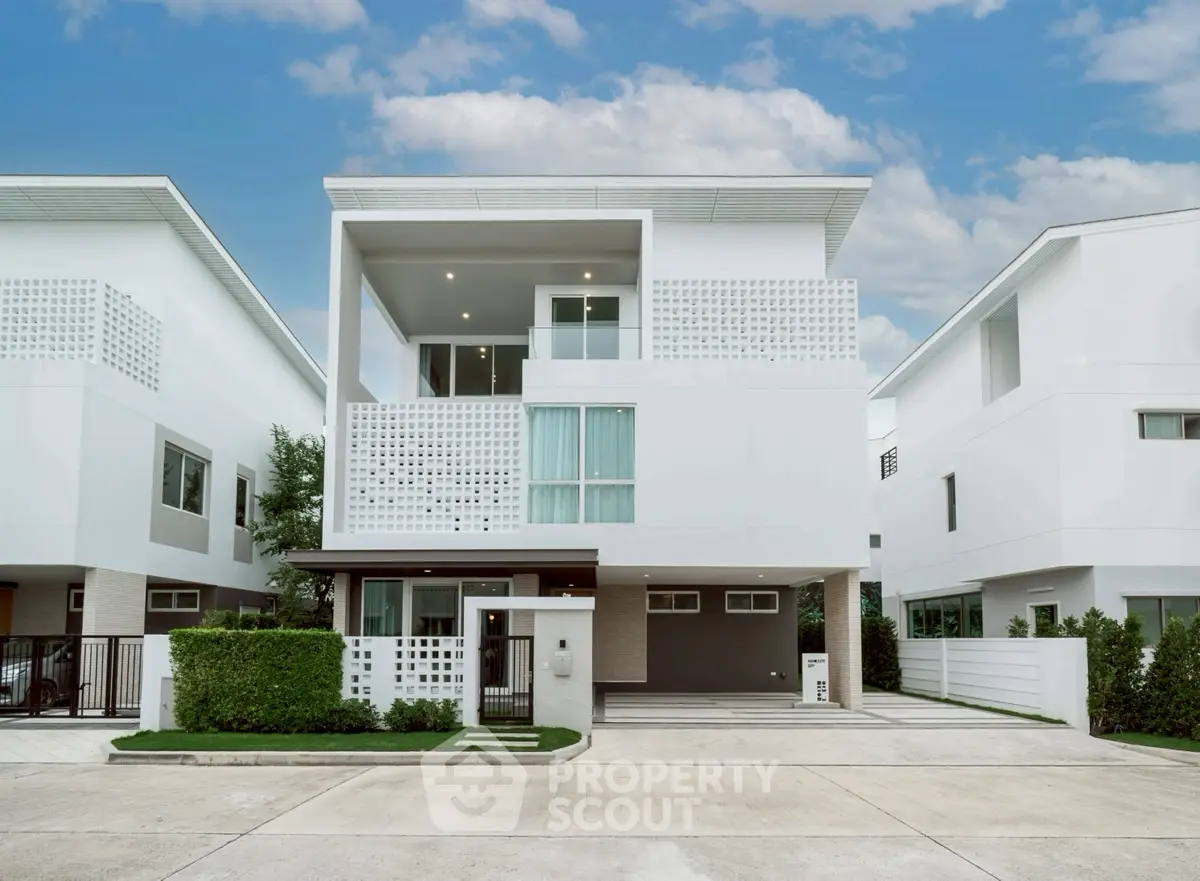 Modern white two-story house with minimalist design and spacious driveway
