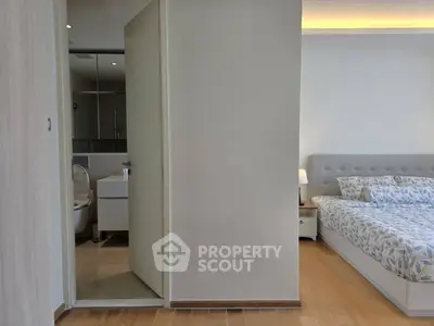 Modern bedroom with ensuite bathroom featuring elegant decor and cozy ambiance.