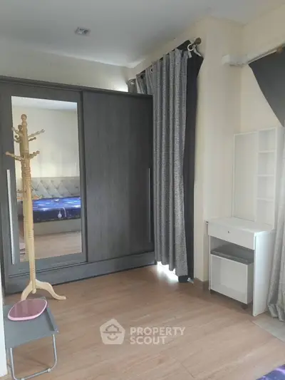 Spacious bedroom with modern wardrobe and elegant curtains, perfect for stylish living.
