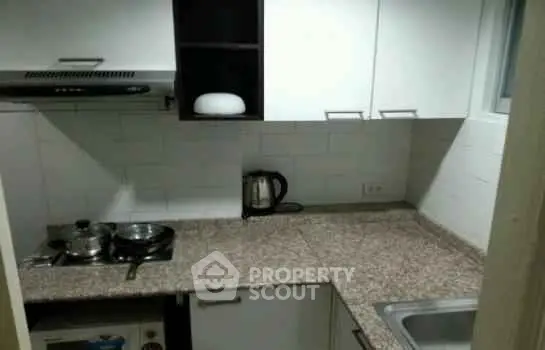 Cozy kitchen with granite countertops and modern appliances in a compact layout.
