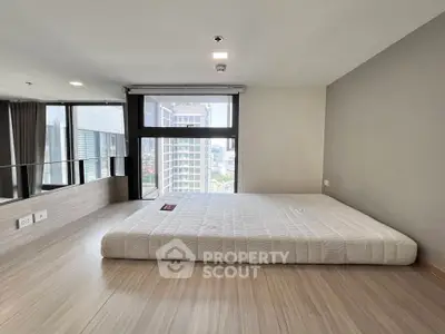 Spacious modern bedroom with city view and large windows